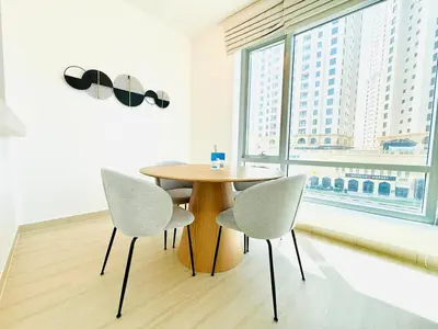 a table and two chairs in a room with a window at Vserve - 1 BR Escape in the Heart of Dubai Marina in Dubai