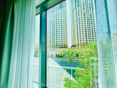 a window with a view of a city with tall buildings at Vserve - 1 BR Escape in the Heart of Dubai Marina in Dubai