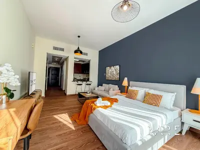 a bedroom with a large bed and a kitchen at Rare Holiday Homes - Mediterranean Cluster - Near Metro - Discovery Garden - Building# Med 83 - R105 in Dubai