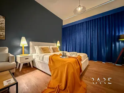 a bedroom with a bed with a table in it at Rare Holiday Homes - Mediterranean Cluster - Near Metro - Discovery Garden - Building# Med 83 - R105 in Dubai
