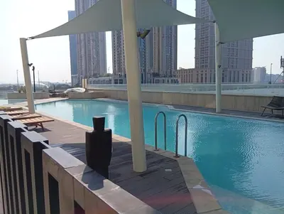 a swimming pool with an umbrella on top of a building at Luxury 2BR in Urban Oasis by Missoni on High Floor in Dubai
