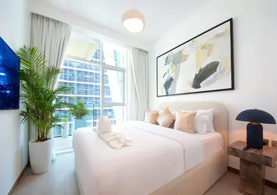 a bedroom with a white bed and a large window at Luxury 2BR in Urban Oasis by Missoni on High Floor in Dubai