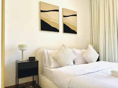 a bedroom with a bed with white sheets and pillows at Vserve - Peaceful 1 BR Getaway in Vibrant JVC in Dubai