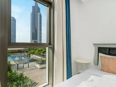 a bedroom with a bed and a window with a view at Burj Crown Luxury 2BR W Balcony & Pool View 8th Floor in Dubai