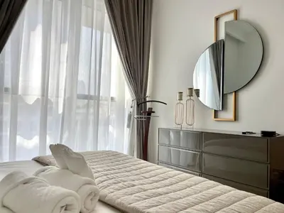 a bedroom with a bed with a mirror and a dresser at Elegant & Luxurious 1BR Apartment in Beach Isle in Dubai