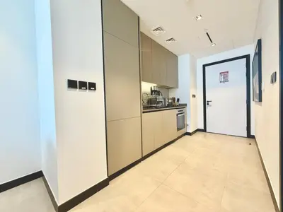 an empty room with a kitchen and a hallway at Vserve - 1 BR Escape With City Views & Canal Vibes in Dubai