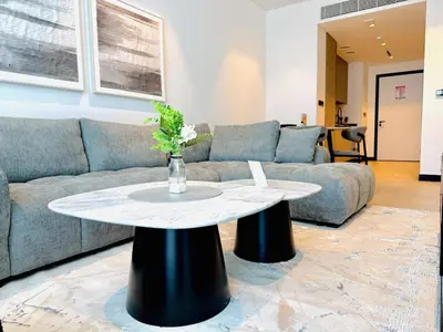 a living room with a couch and a table at Vserve - 1 BR Escape With City Views & Canal Vibes in Dubai