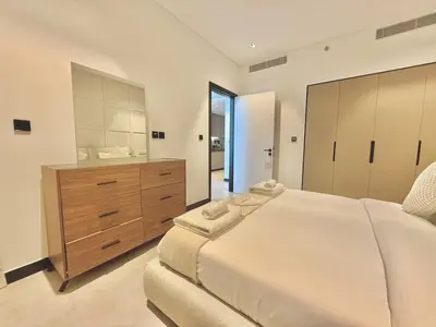 a bedroom with a large bed and a bathroom at Vserve - 1 BR Escape With City Views & Canal Vibes in Dubai