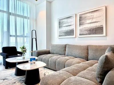 a living room with a couch and a table at Vserve - 1 BR Escape With City Views & Canal Vibes in Dubai