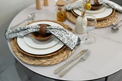 a table with plates and a bowl and a glass at Trendy Studio Apartment in Binghatti Crystals in Dubai