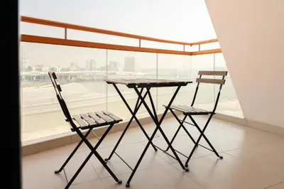 two chairs and a table in front of a window at Trendy Studio Apartment in Binghatti Crystals in Dubai