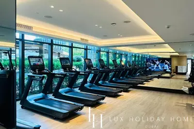 a gym with rows of treadmills in a building at LUX The Address Opera Downtown Suite in Dubai