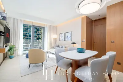 a living room with a table and chairs at LUX The Address Opera Downtown Suite in Dubai