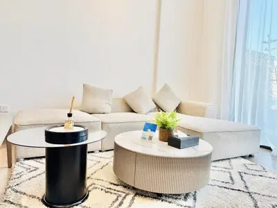 a living room with a couch and a table at Vserve -Elegant Penthouse Stay in the Heart of JVC in Dubai