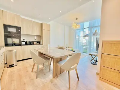 a kitchen and dining room with a table and chairs at Vserve -Elegant Penthouse Stay in the Heart of JVC in Dubai