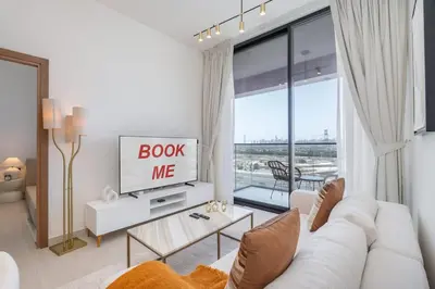 a living room with a white couch and a tv at Golden Stays - Binghatti Onyx I Brand New 1BR I Modern and Fully Furnished in Dubai