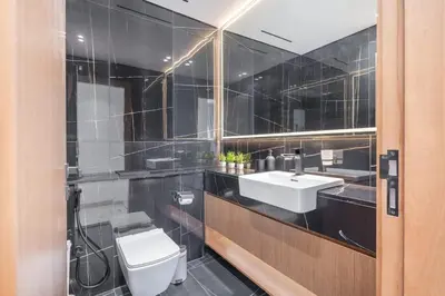 a bathroom with a white toilet and a sink at Golden Stays - Binghatti Onyx I Brand New 1BR I Modern and Fully Furnished in Dubai
