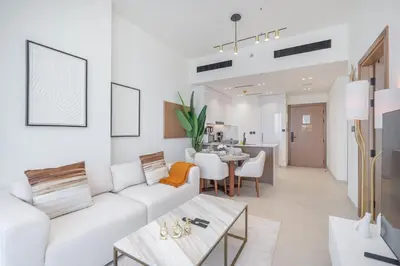 a living room with a white couch and a table at Golden Stays - Binghatti Onyx I Brand New 1BR I Modern and Fully Furnished in Dubai