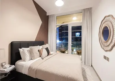 a bedroom with a bed and a large window at Luxury 2 BR Missoni Building Canal & Pool View in Dubai