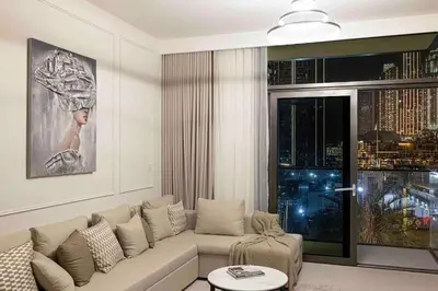 a living room with a white couch and a large window at Luxurious Crown - Downtown - Fountains View in Dubai
