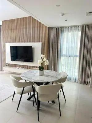a dining room with a table and chairs and a television at Luxurious Crown - Downtown - Fountains View in Dubai