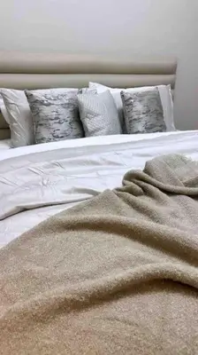 a white bed with a blanket on top of it at Luxurious Crown - Downtown - Fountains View in Dubai