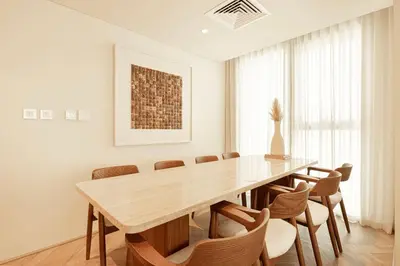 a dining room with a wooden table and chairs at Seraya Residence 5 - 4BDR - Burj Views - Private Jacuzzi in Dubai