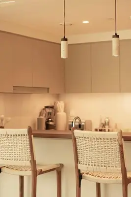 a kitchen with two chairs and a kitchen counter at Seraya Residence 5 - 4BDR - Burj Views - Private Jacuzzi in Dubai