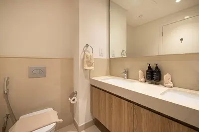 a bathroom with a toilet and a sink and a mirror at Seraya Residence 5 - 4BDR - Burj Views - Private Jacuzzi in Dubai