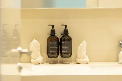 two bottles ofodorizers sitting on a shelf in a bathroom at Seraya Residence 5 - 4BDR - Burj Views - Private Jacuzzi in Dubai