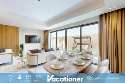 a living room with a table and chairs and a couch at Elegant - Three Bed Villa in Jumeirah Golf Estate in Dubai