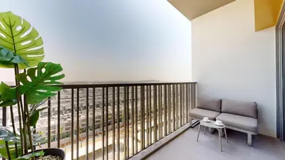 a balcony with a couch and a view of a city at Mag Eye 920 - Spacious Studio in Meydan in Dubai