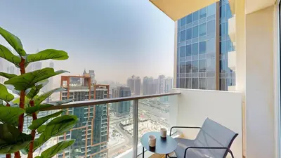 a balcony with a chair and a view of a city at Stunning One Bedroom in the Marina in Dubai