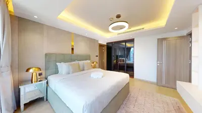 a bedroom with a large white bed and a bathroom at Stunning One Bedroom in the Marina in Dubai