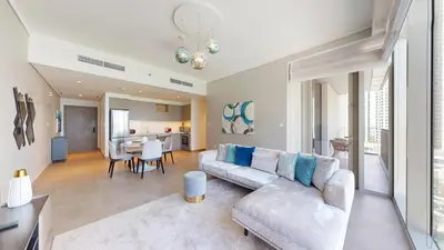 a living room with a couch and a dining room at Creek Gate - Spacious Two Bed in Creek Harbour in Dubai