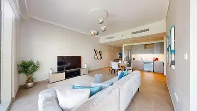 a living room with a white couch and a television at Creek Gate - Spacious Two Bed in Creek Harbour in Dubai