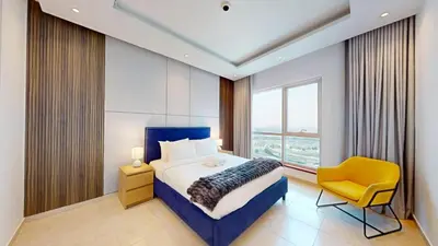 a bedroom with a bed and a yellow chair at Vacationer I Elegant 2 Bed I City View I Close to Barasti Beach I Marina Heights in Dubai