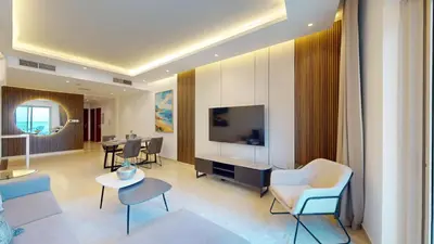 a living room with a tv and a couch and chairs at Vacationer I Elegant 2 Bed I City View I Close to Barasti Beach I Marina Heights in Dubai