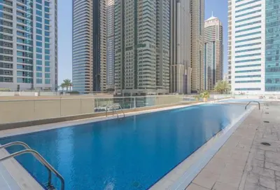 a large swimming pool in a city with tall buildings at Vacationer I Elegant 2 Bed I City View I Close to Barasti Beach I Marina Heights in Dubai