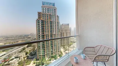 a balcony with a chair and a view of a city at Vacationer I Elegant 2 Bed I City View I Close to Barasti Beach I Marina Heights in Dubai