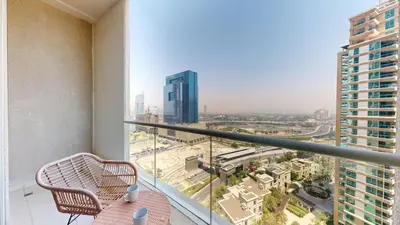 a balcony with a chair and a view of a city at Vacationer I Elegant 2 Bed I City View I Close to Barasti Beach I Marina Heights in Dubai