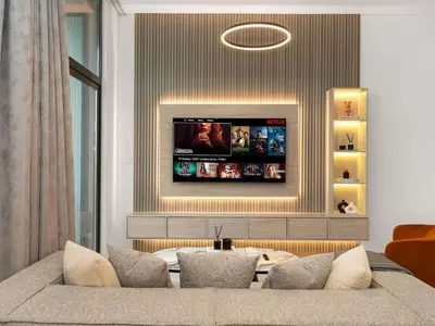 a living room with a couch and a flat screen tv at NEW Luxury 2 Bed in Belgravia Heights in JVC in Dubai
