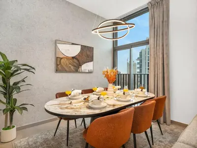 a dining room with a table and chairs and a window at NEW Luxury 2 Bed in Belgravia Heights in JVC in Dubai