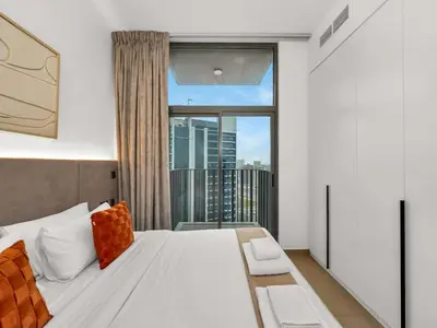 a bedroom with a bed and a large window at NEW Luxury 2 Bed in Belgravia Heights in JVC in Dubai