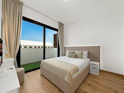 a bedroom with a large bed and a large window at Brand New Luxury Apartment in JVC with Padel Court in Dubai