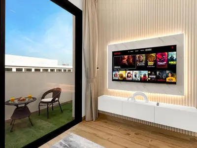 a living room with a tv on the wall at Brand New Luxury Apartment in JVC with Padel Court in Dubai