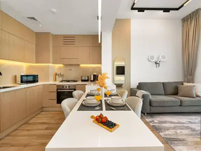a kitchen and living room with a table and a couch at Brand New Luxury Apartment in JVC with Padel Court in Dubai