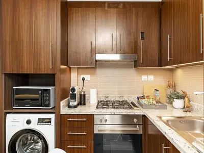 a kitchen with a stove top oven next to a microwave at The Dubai Mall Suite Luxury 1-Bed Near Burj Khalifa in Dubai