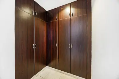 a closet with wooden cabinets in a room at Luxury 2BR Haven with Expansive Terrace and Elegance in Dubai