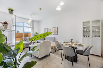 a living room with a table and chairs at Luxury 2BR Haven with Expansive Terrace and Elegance in Dubai